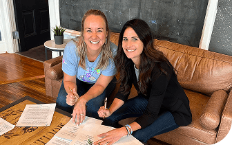 Maggie and Jenny are signing documents when Maggie officially became a minority owner